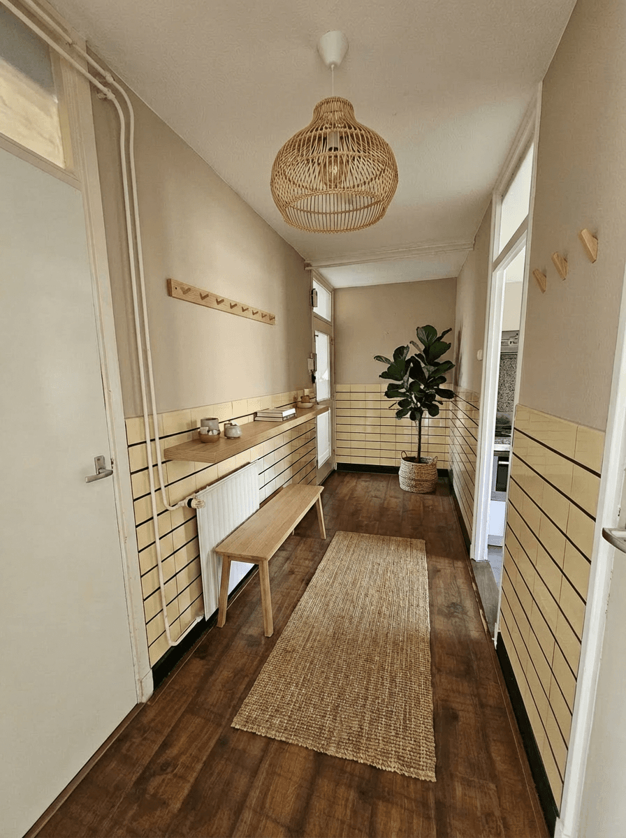 Entree met originele tegels als karaktervolle basis, aangevuld met lichte tinten en warme houten elementen.